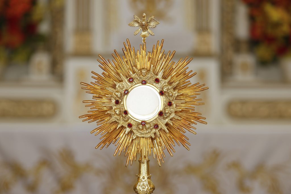 A consecrated host inside a monstrance in front of the high altar.